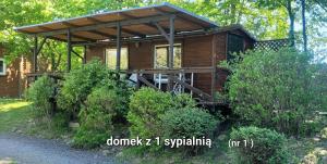 Cabaña de madera en el bosque con porche en Stanica pod Zadzierną Kemping Domki letniskowe, en Lubawka