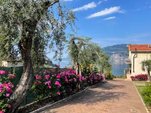 a walkway with flowers and a view of the water at Appartamenti Villa Eden in Malcesine