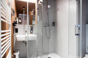 une salle de bain avec douche et lavabo dans l'établissement MEININGER Hotel Bremen Hauptbahnhof, à Brême 38 autres photos