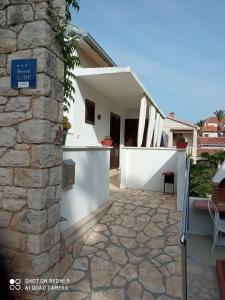 a house with a stone walkway in front of a building at Apartment M&J Supetar in Supetar