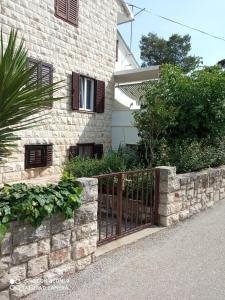 una recinzione in pietra di fronte a una casa di Apartment M&J Supetar a Supetar (San Pietro di Brazza)