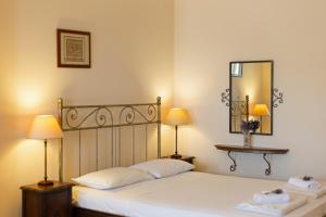 a bedroom with a bed with two lamps and a mirror at Spertos Apartments in Órmos