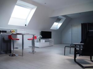 salon ze stołem i czerwonymi krzesłami w obiekcie Studio de charme à la ferme près de Lille, 50m² avec cuisine équipée et parking sécurisé - FR-1-510-173 w mieście Halluin