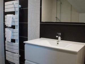 W łazience znajduje się umywalka, lustro i ręczniki. w obiekcie Studio de charme à la ferme près de Lille, 50m² avec cuisine équipée et parking sécurisé - FR-1-510-173 w mieście Halluin +10 zdjęć