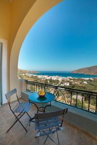a table and chairs on a balcony with a view of the ocean at Spertos Apartments in Órmos