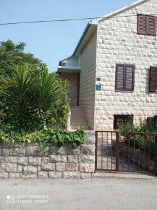 a brick house with a fence in front of it at Apartment M&J Supetar in Supetar