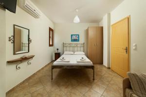 a bedroom with a bed and a mirror on the wall at Spertos Apartments in Órmos