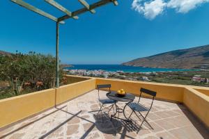 a table and chairs on a patio with a view of the ocean at Spertos Apartments in Órmos