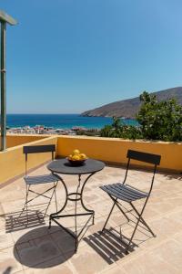 a table and chairs on a patio with a view of the ocean at Spertos Apartments in Órmos