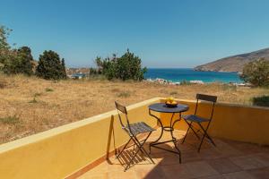 a table and chairs on a balcony with a view of the ocean at Spertos Apartments in Órmos