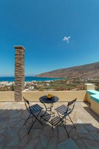 a table and chairs on a patio with a view of the ocean at Spertos Apartments in Órmos