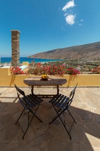 a table and chairs on a patio with a view of the ocean at Spertos Apartments in Órmos