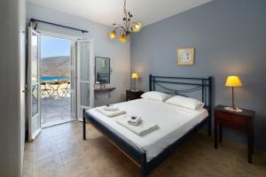 a bedroom with a bed and a view of the ocean at Spertos Apartments in Órmos