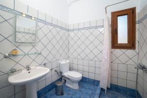 a bathroom with a toilet and a sink at Spertos Apartments in Órmos