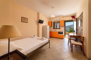 a bedroom with a bed and a kitchen with a table at Spertos Apartments in Órmos