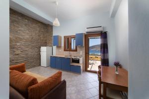 a kitchen and living room with a couch and a table at Spertos Apartments in Órmos