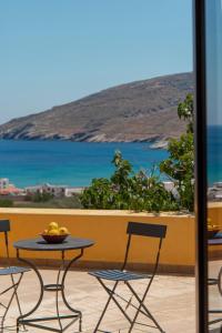a table and chairs on a balcony with a view of the ocean at Spertos Apartments in Órmos