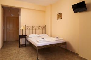 a bedroom with a bed with two towels on it at Spertos Apartments in Órmos