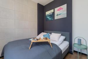 a bedroom with a bed with a table on it at Port Gdynia Apartment by Renters in Gdynia