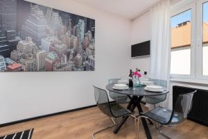 a dining room with a table and chairs and a painting at Port Gdynia Apartment by Renters in Gdynia