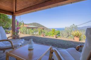 d'une terrasse avec une table et des chaises et une vue. dans l'établissement HelloElba Villetta Azzurra, à Portoferraio