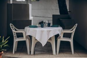 a table with a white table cloth and two chairs at Saturo Apartments in Leporano