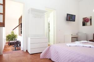 a white bedroom with a bed and a desk at Country Villa San Vito Bay in San Vito lo Capo