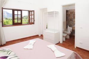 a white room with a bed and a bathroom at Country Villa San Vito Bay in San Vito lo Capo