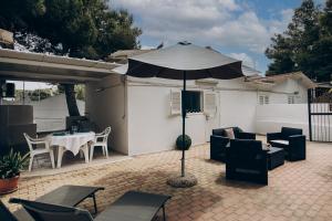 a patio with an umbrella and a table and chairs at Saturo Apartments in Leporano +13 photos