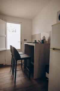 a kitchen with a table and a chair and a refrigerator at Saturo Apartments in Leporano