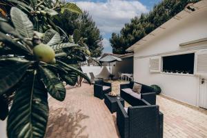 a patio with couches and a tree and a television at Saturo Apartments in Leporano