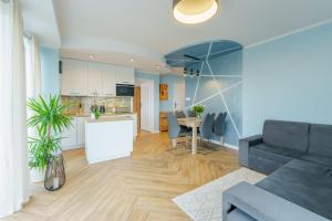 salon i kuchnia z kanapą i stołem w obiekcie Apartament Doro w Kołobrzegu
