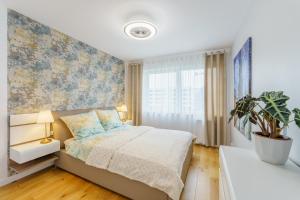 sypialnia z łóżkiem i doniczką w obiekcie Apartament Doro w Kołobrzegu