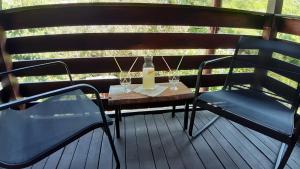 a table and two chairs on a deck with wine glasses at Casa Camelia in Sovata