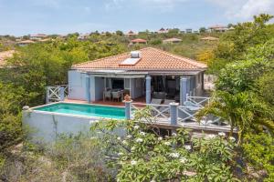 a villa with a swimming pool and a house at Villa Coral Breeze in Willemstad
