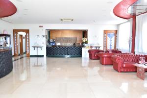 a living room with red couches and a kitchen at Hotel Paradiso in Lago Patria