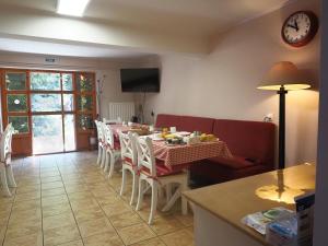 ソバタにあるCasa Cameliaのテーブルと椅子と時計のあるダイニングルーム