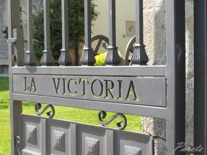 een metalen poort met een bord dat la victoria leest bij Posada La Victoria in Miengo