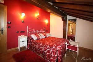 una camera rossa con letto e parete rossa di Posada La Victoria a Miengo