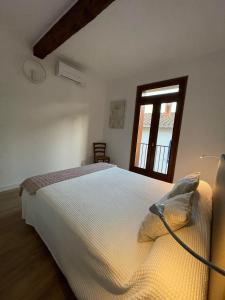 een slaapkamer met een wit bed en een raam bij Appartement centre Collioure 63 m² avec terrasse à 3 minutes des plages in Collioure