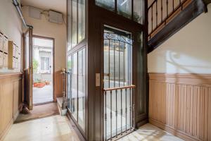 pasillo con puerta de madera con paneles de cristal en Cosy Apartment Malasaña, en Madrid