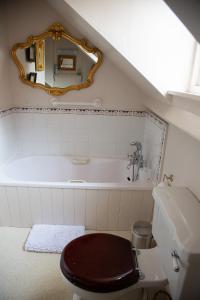 a bathroom with a toilet and a bath tub at The Old Bakehouse, Walsingham in Little Walsingham