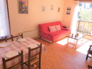 a living room with a red couch and a table at Appartement Saint-Lary-Soulan, 2 pièces, 6 personnes - FR-1-457-149 in Saint-Lary-Soulan