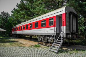 a red and silver train car sitting on the tracks at Palanga Camping Hostel in Palanga