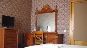 a bedroom with a dresser and a mirror and a bed at Villand Hotel with Free Private Parking and Self Check In in Riga