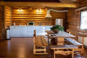 a dining room with a table and a kitchen at Hunter's Lodge in Padure