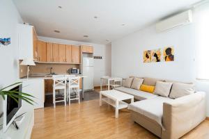 sala de estar con sofá y cocina en Cosy Apartment Malasaña, en Madrid