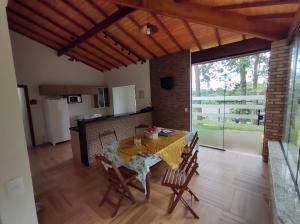 Una cocina y un comedor con mesa y sillas. en Chácara em Atibaia, en Atibaia