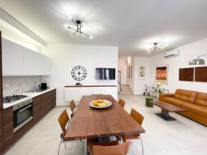a kitchen and living room with a wooden table and chairs at Casa Le Volte by Ferrocino Holiday in Nardò