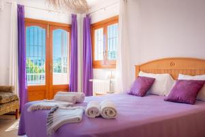 a bedroom with a purple bed with towels on it at Can Toni in Sant Josep de Sa Talaia